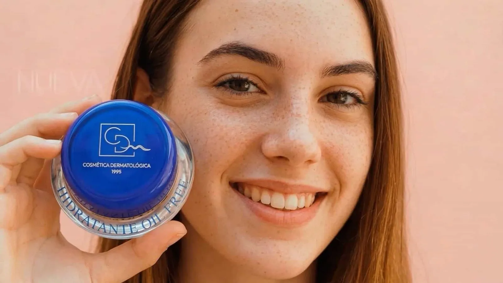 Chica sonriendo con un bote de crema Siliderm